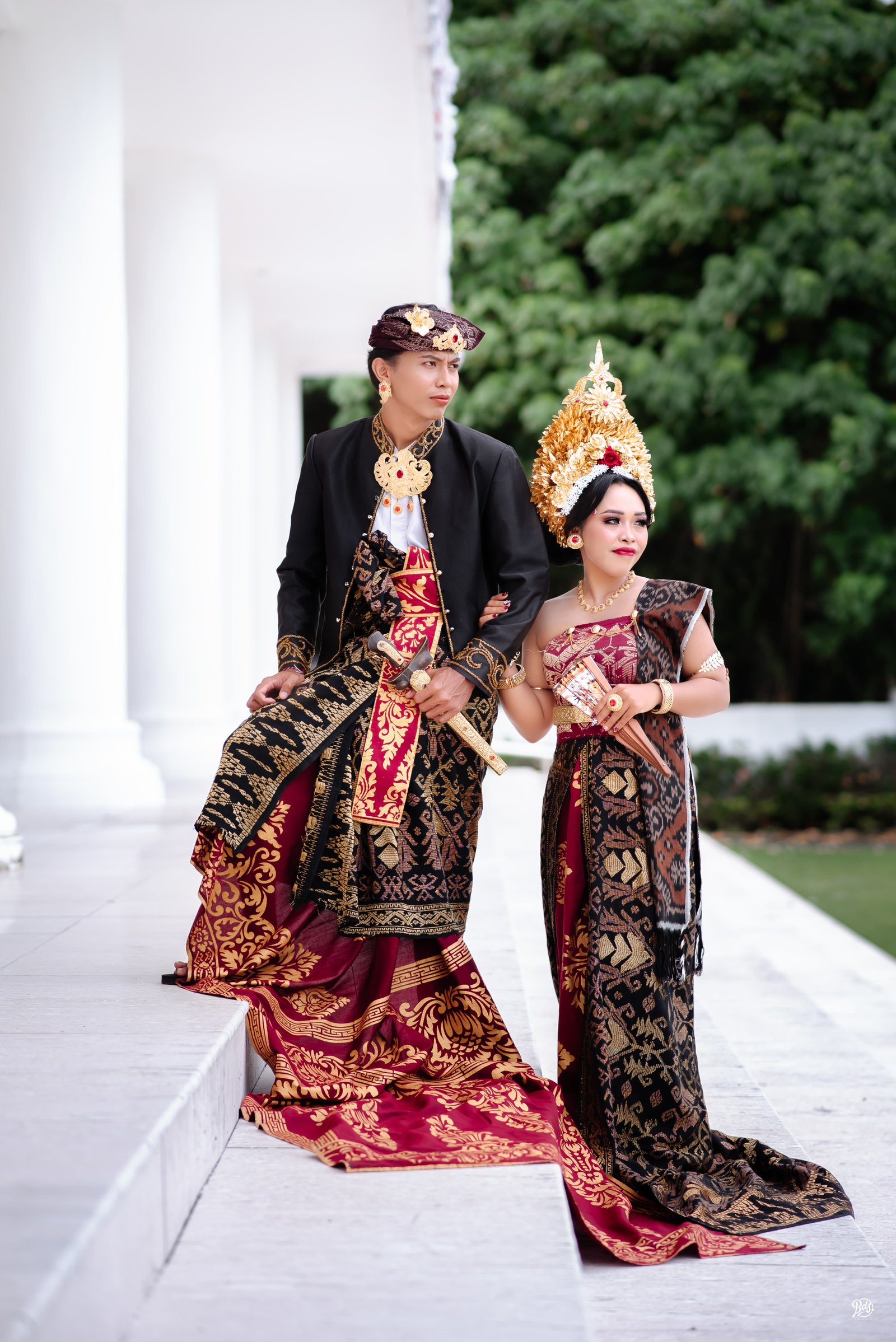 Pasangan pengantin berjalan di area pilar putih