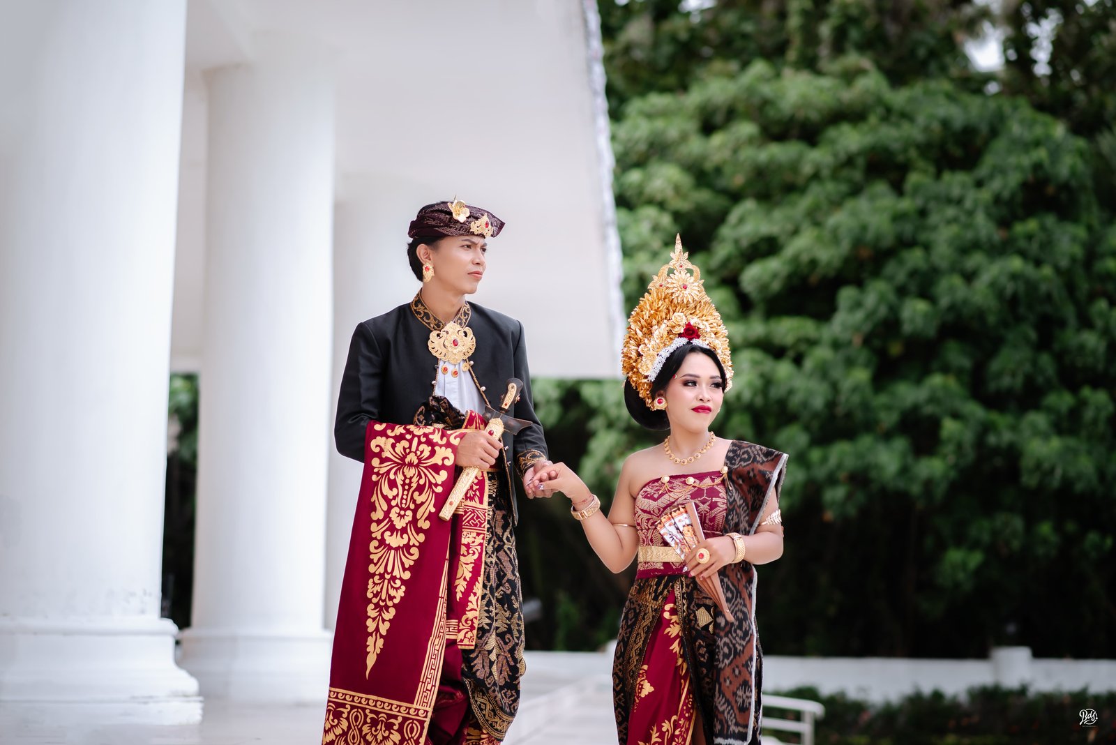 Pasangan pengantin Bali berpegangan tangan